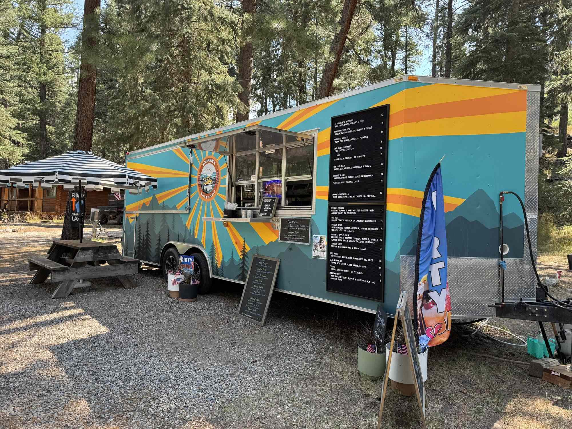 The enclosed trailer set up at Blue Spruce Campground, menu wall and service window facing the guests