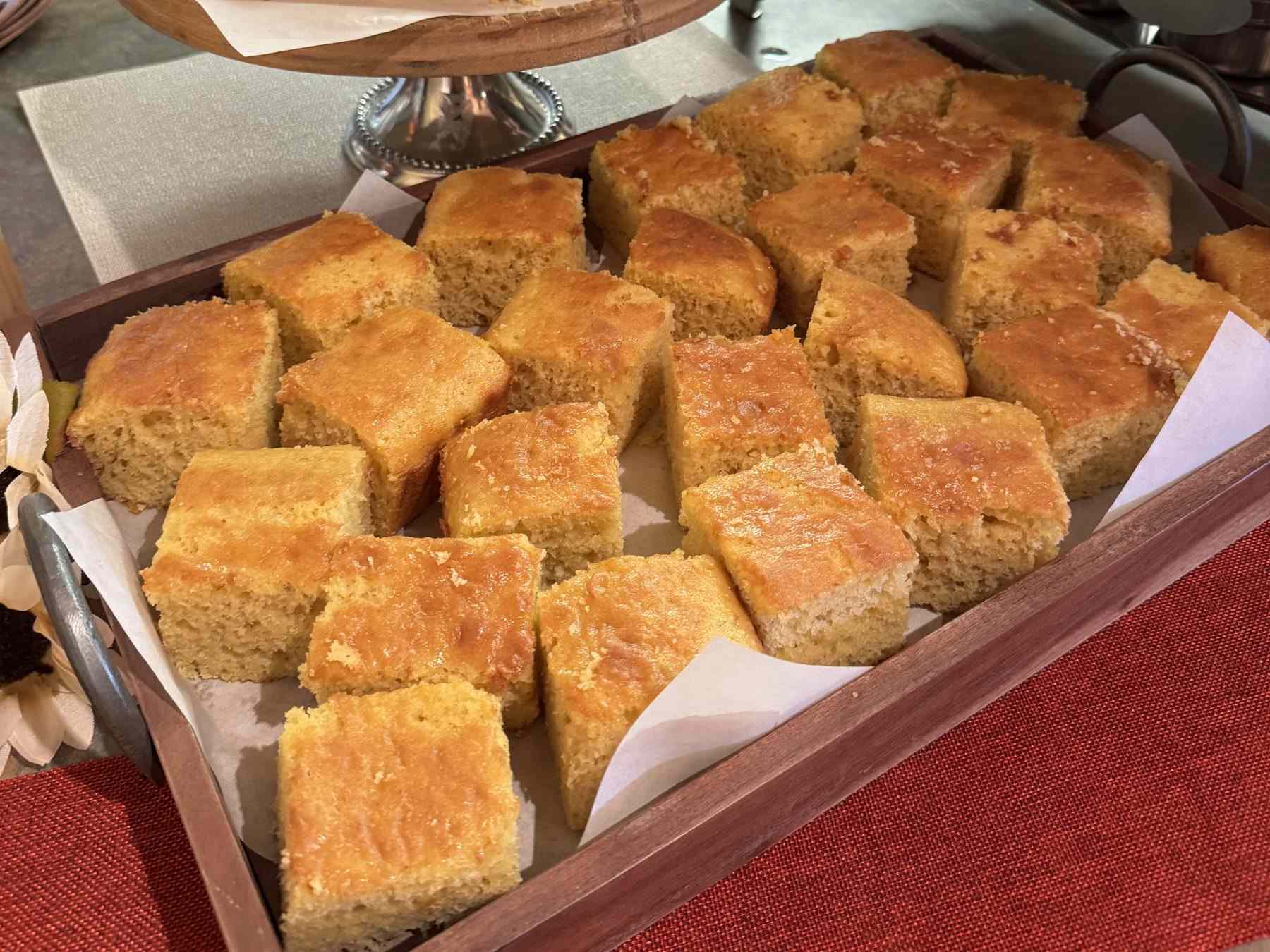 Squares of cornbread on a cake stand and a wooden tray