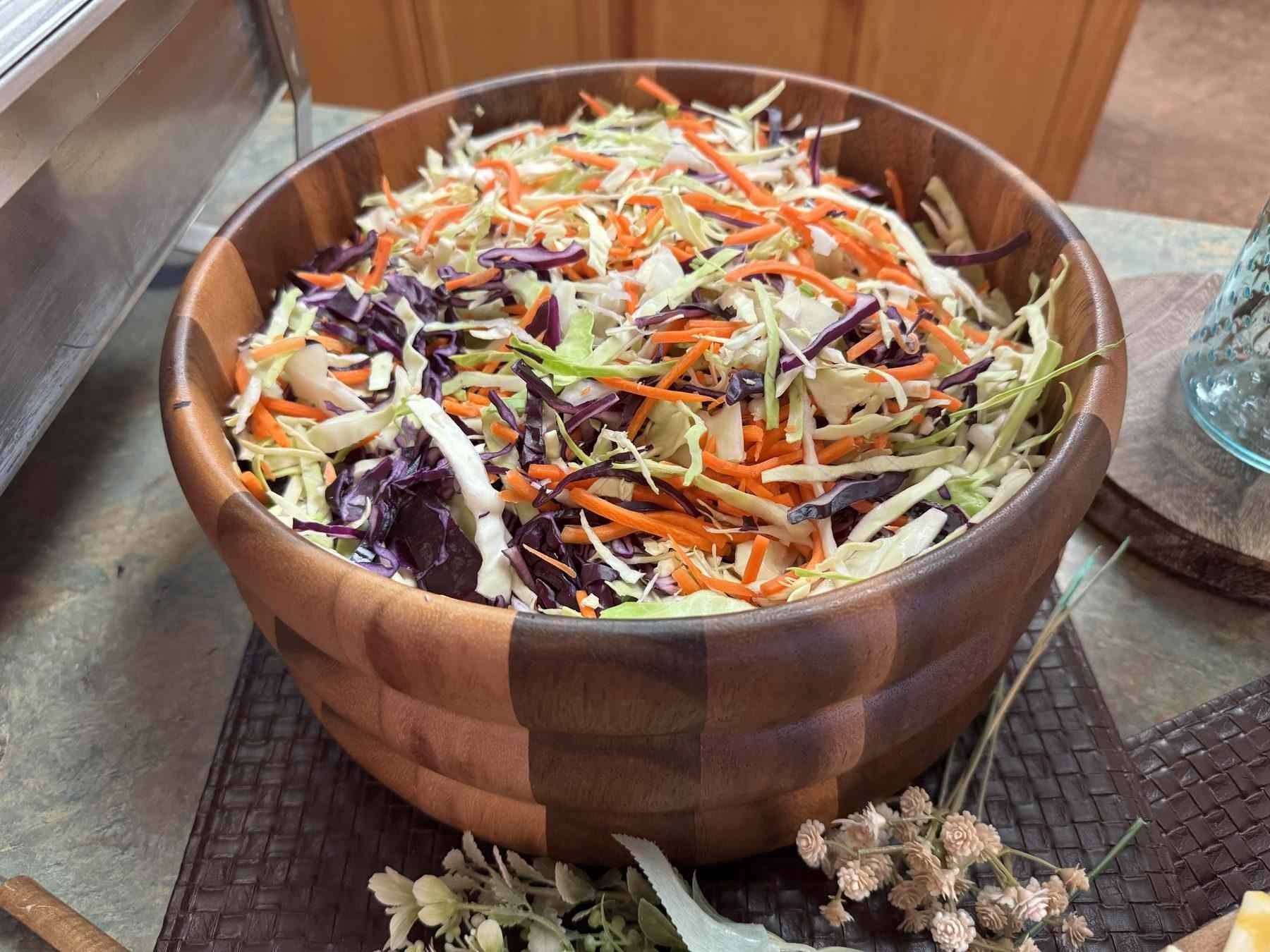 Slaw with red cabbage and carrot in a wooden bowl